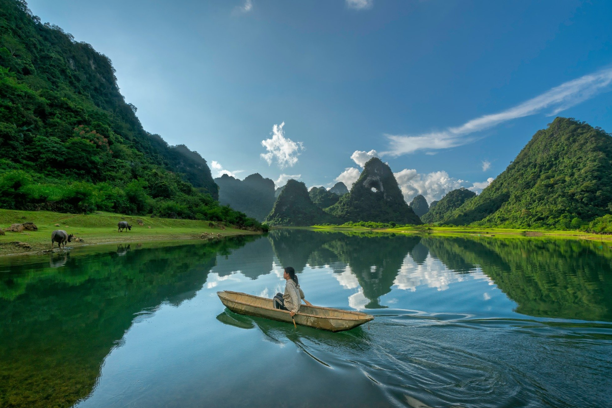 Quay Son River reflecting rice fields and karst mountains near Ngoc Con Town