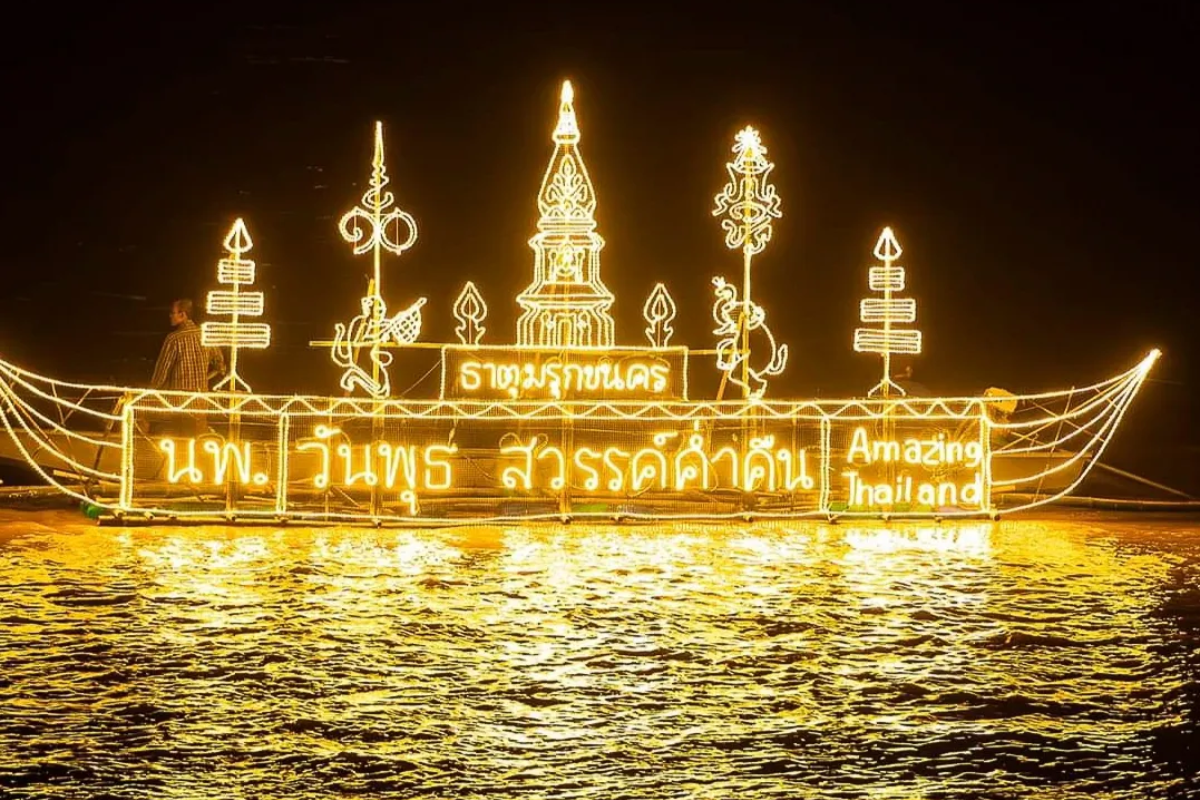 Candle-lit boat floating on the Mekong River during the Nakhon Phanom procession