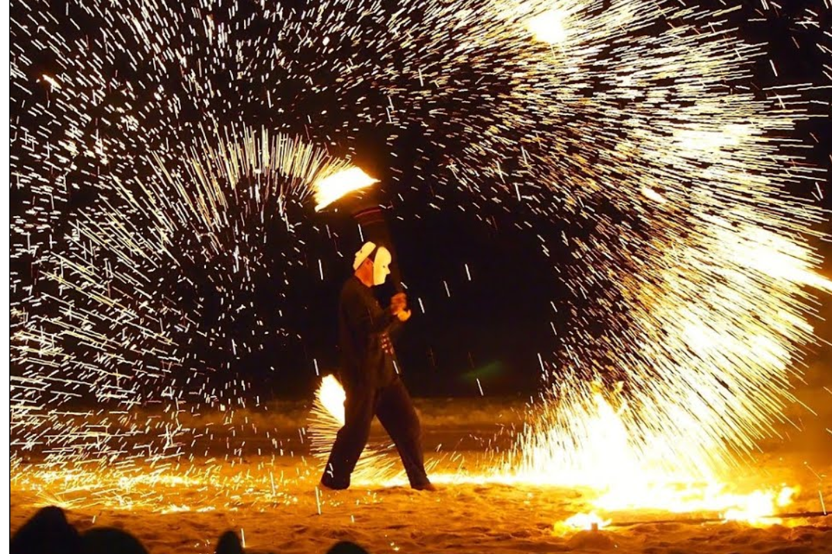 Fire dancer performing on the beach at night in Koh Phi Phi