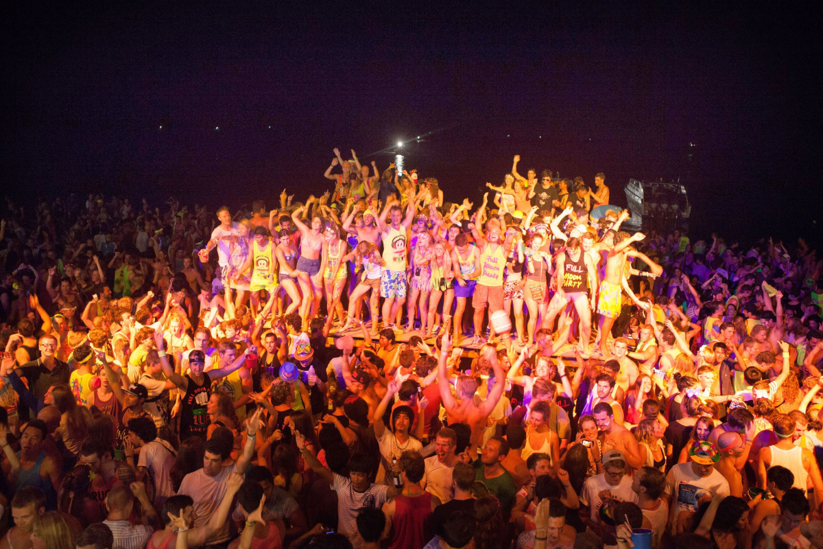 Crowd dancing under moonlight at Full Moon Party on Haad Rin Beach