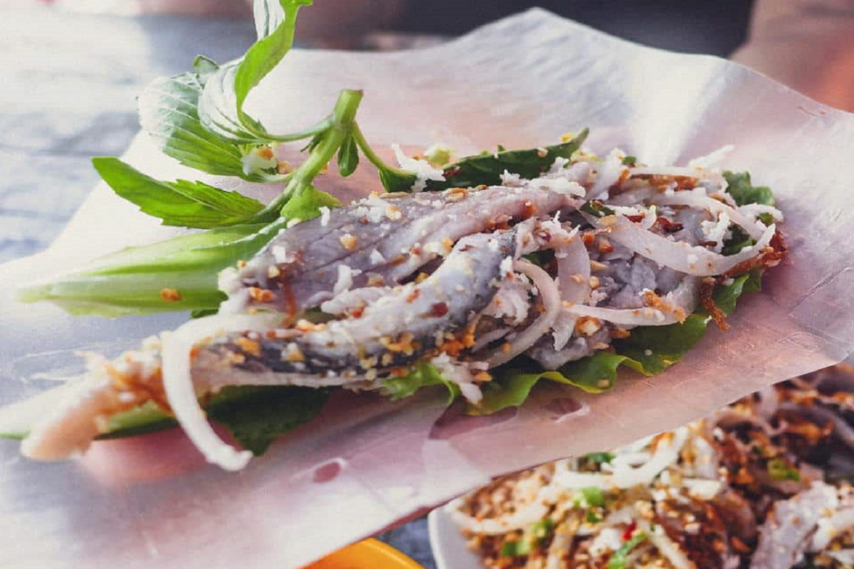 A plate of Goi Ca Trich, a fresh herring salad with herbs and dipping sauce
