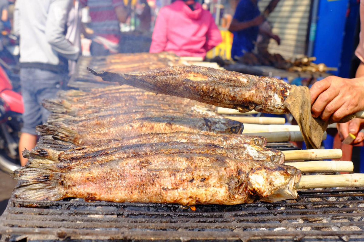 Crispy grilled stream fish served with herbs and dipping sauce