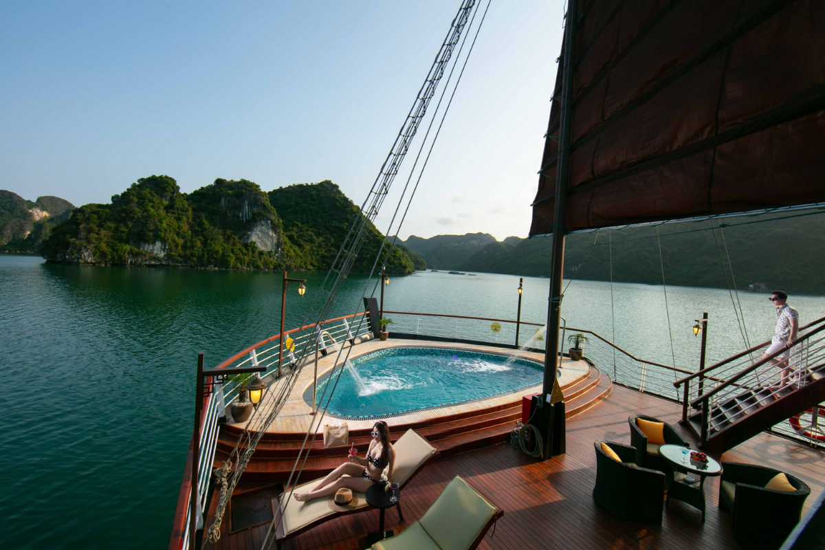 Luxury cruise ship sailing through misty waters of Ha Long Bay in August