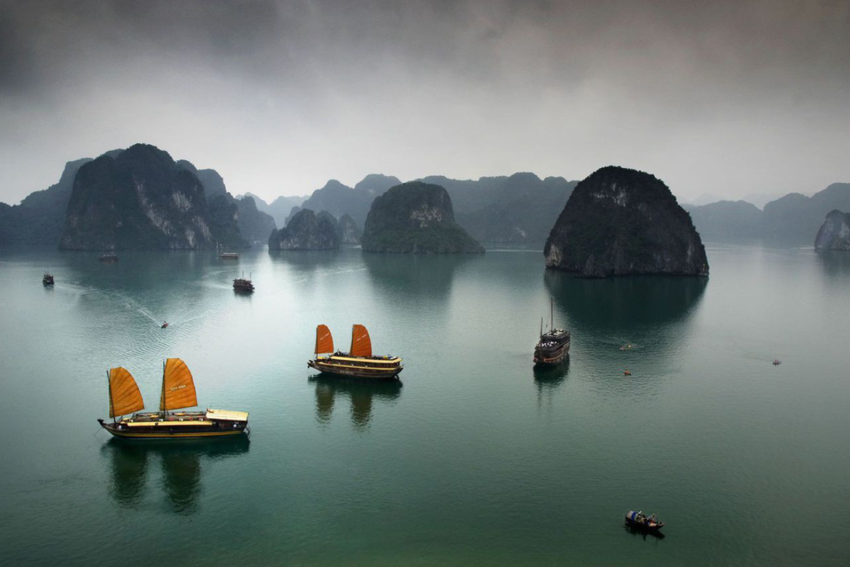 Misty morning over Ha Long Bay in February with limestone islands partially hidden in fog