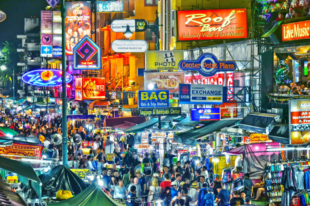 Crowded Khao San Road in Bangkok with neon signs and street vendors