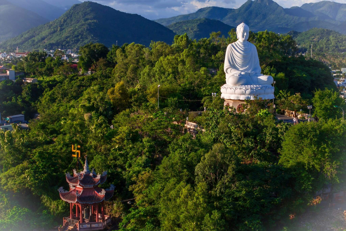 Statue of Buddha at Long Son Pagoda surrounded by tropical greenery