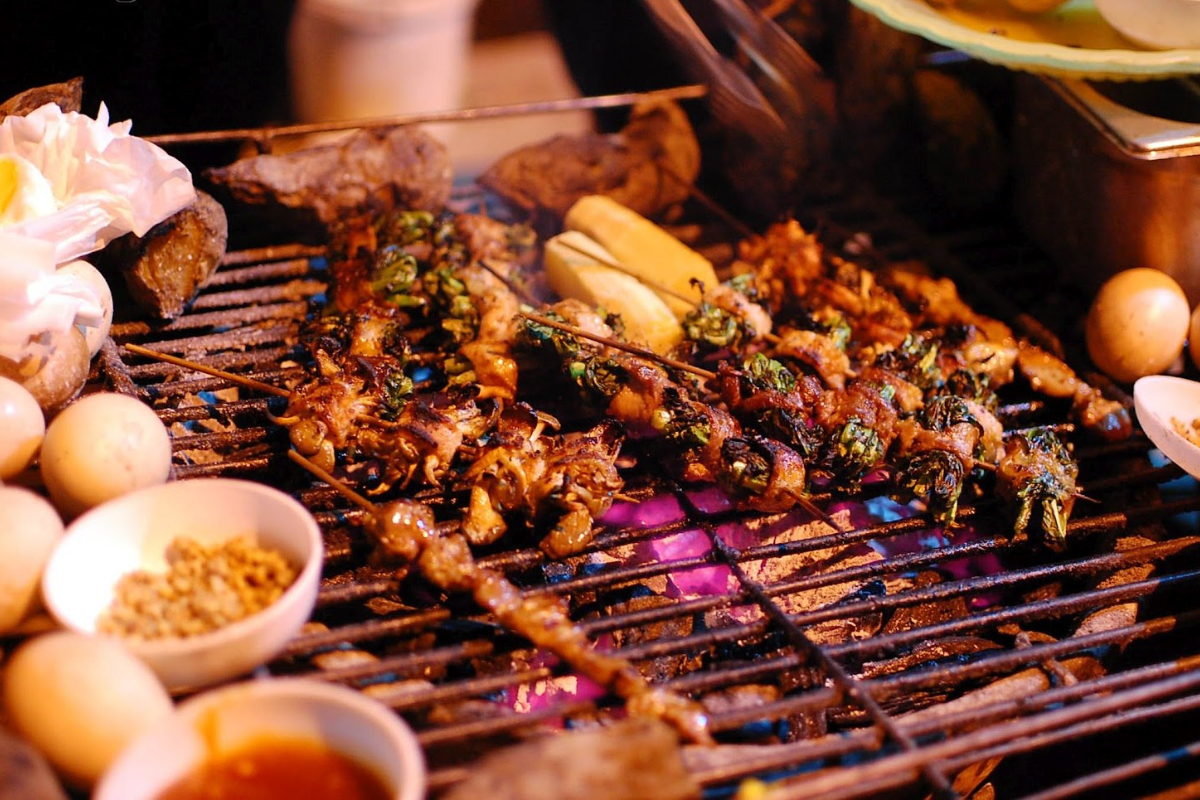 Sapa street barbecue with skewered meats and sticky rice cooking on open fire