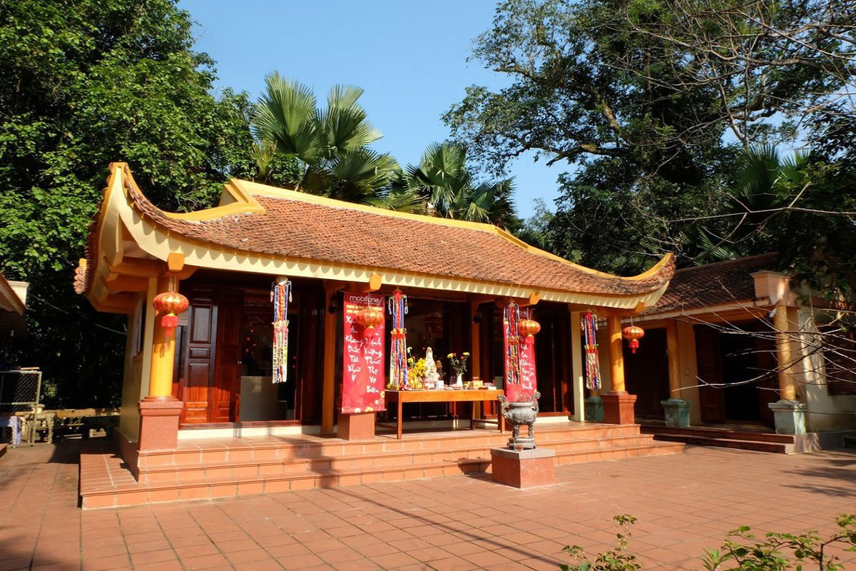 Traditional Buddhist architecture at Sung Khanh Pagoda with forest backdrop