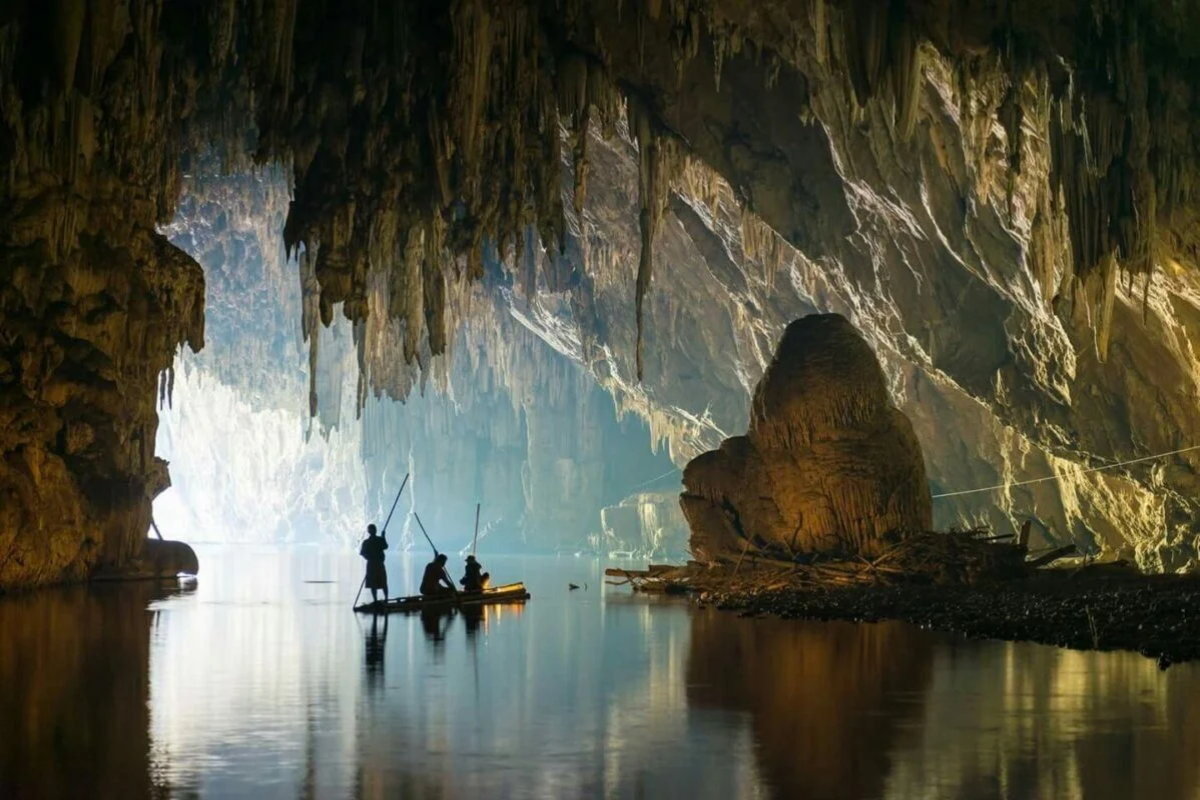 Interior view of Tham Lod Cave with rock formations and underground river