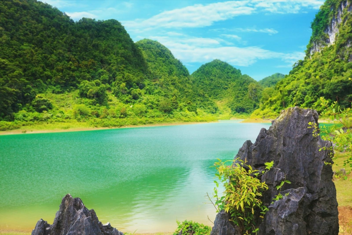 Emerald green Thang Hen Lake in Cao Bang with steep cliffs
