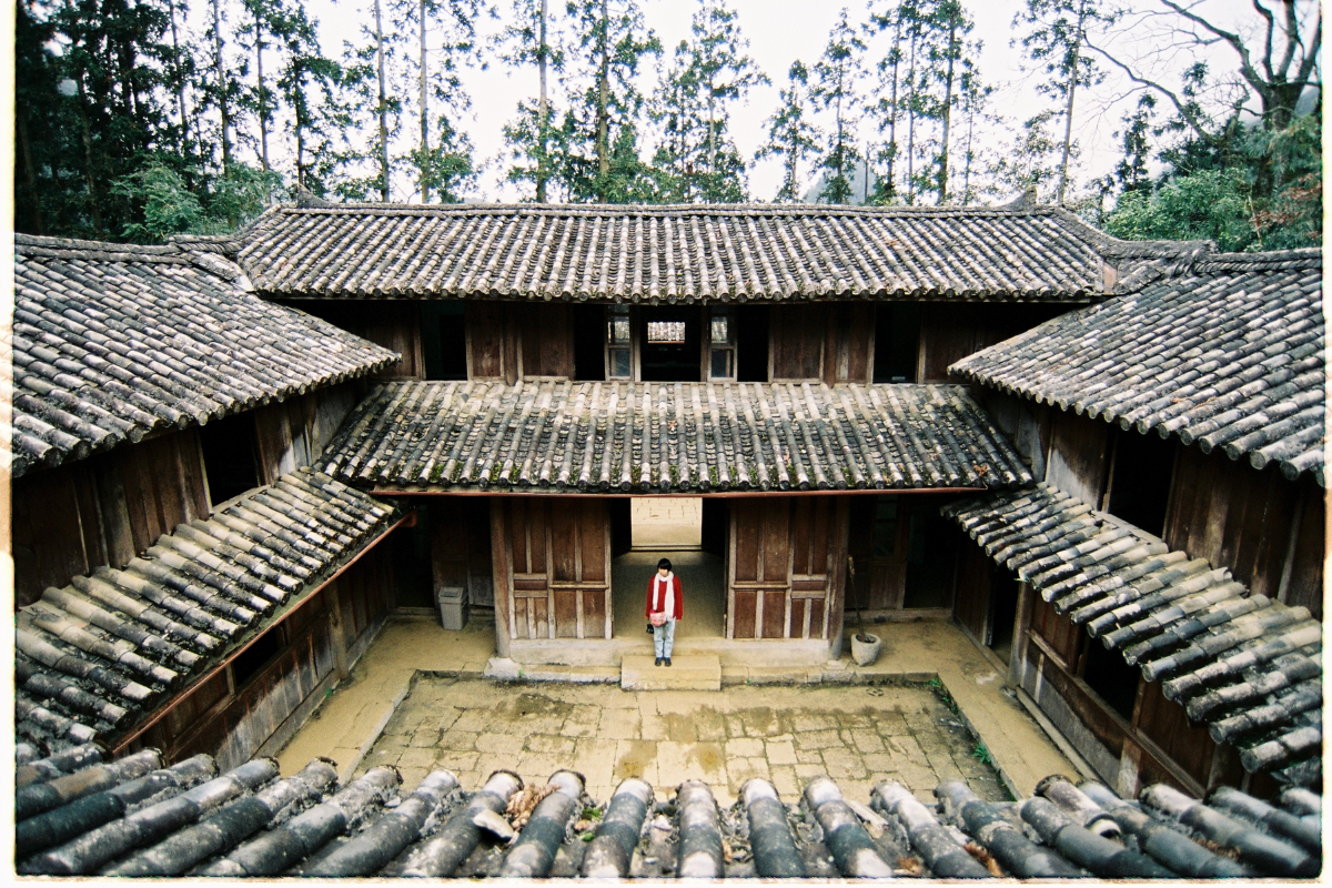 Ancient royal-style architecture of Vuong Family’s Palace surrounded by pine trees