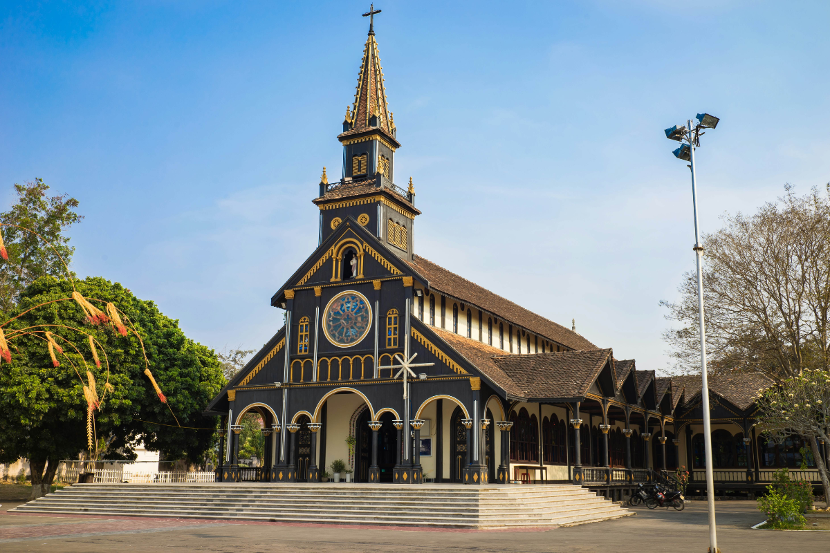 Wooden Church in Kontum with native carvings and tall wooden bell tower