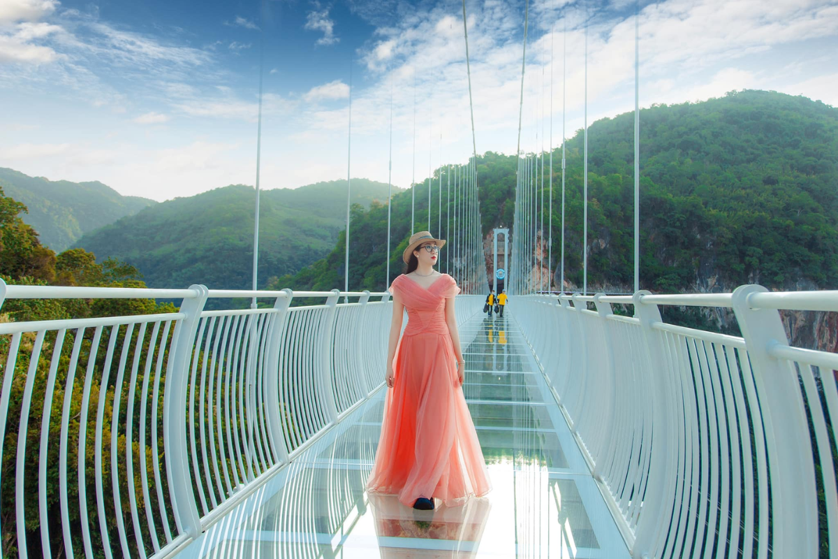 Tourists walking on the Moc Chau glass bridge with mountain views