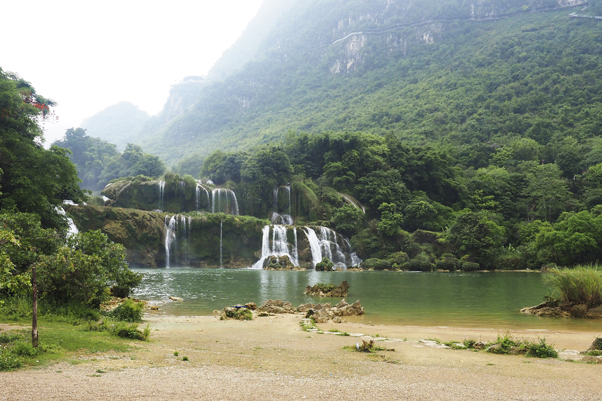 Panoramic view of Ban Gioc Waterfall in September with high water flow and green surroundings