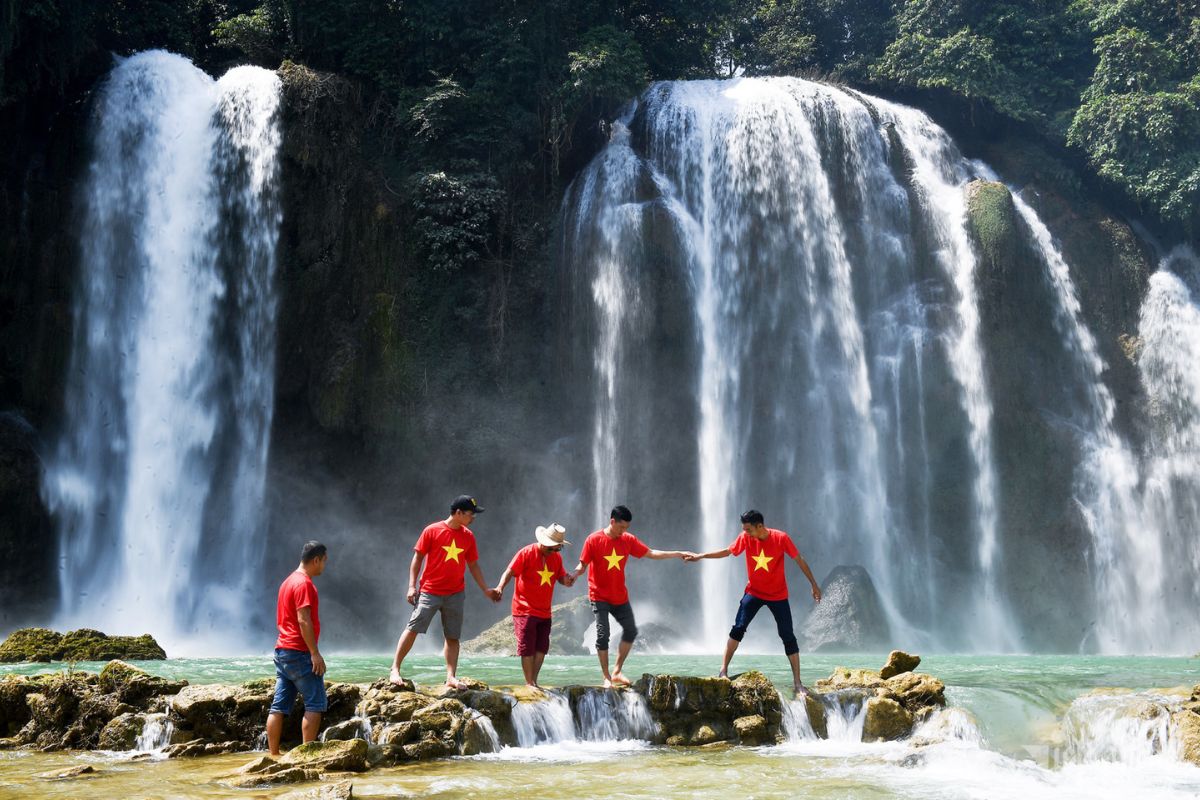 Ban Gioc Waterfall in December with light mist and serene flow against limestone cliffs