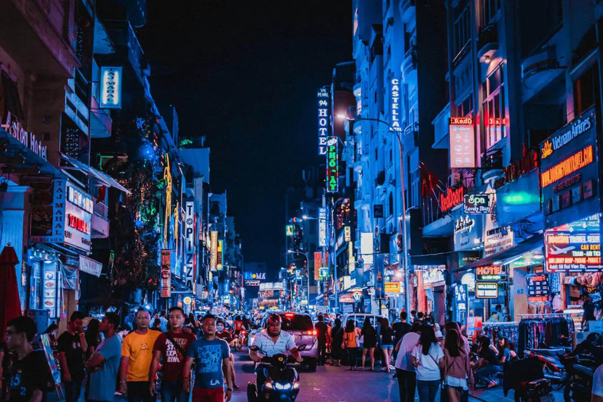 Crowded Bui Vien Walking Street lit up at night with neon signs