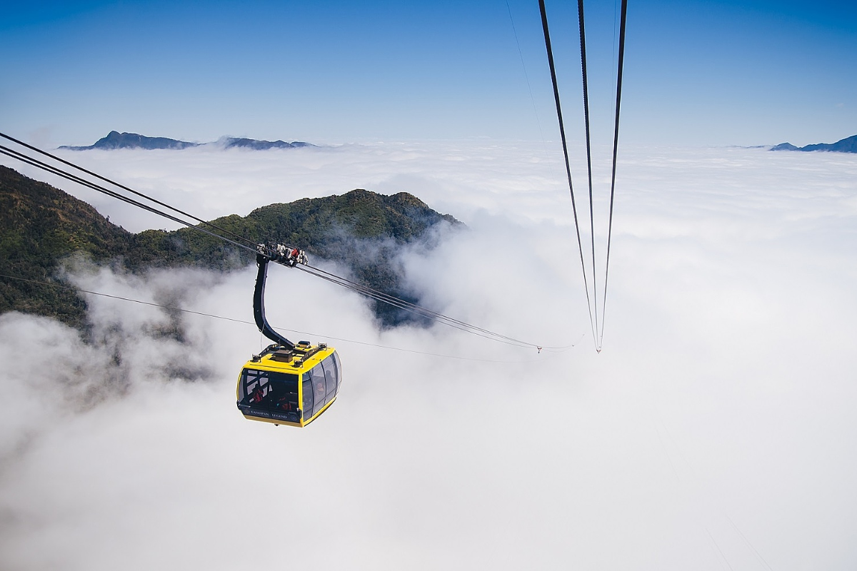 Cable car ascending to Mount Fansipan above green mountain valleys in Sapa