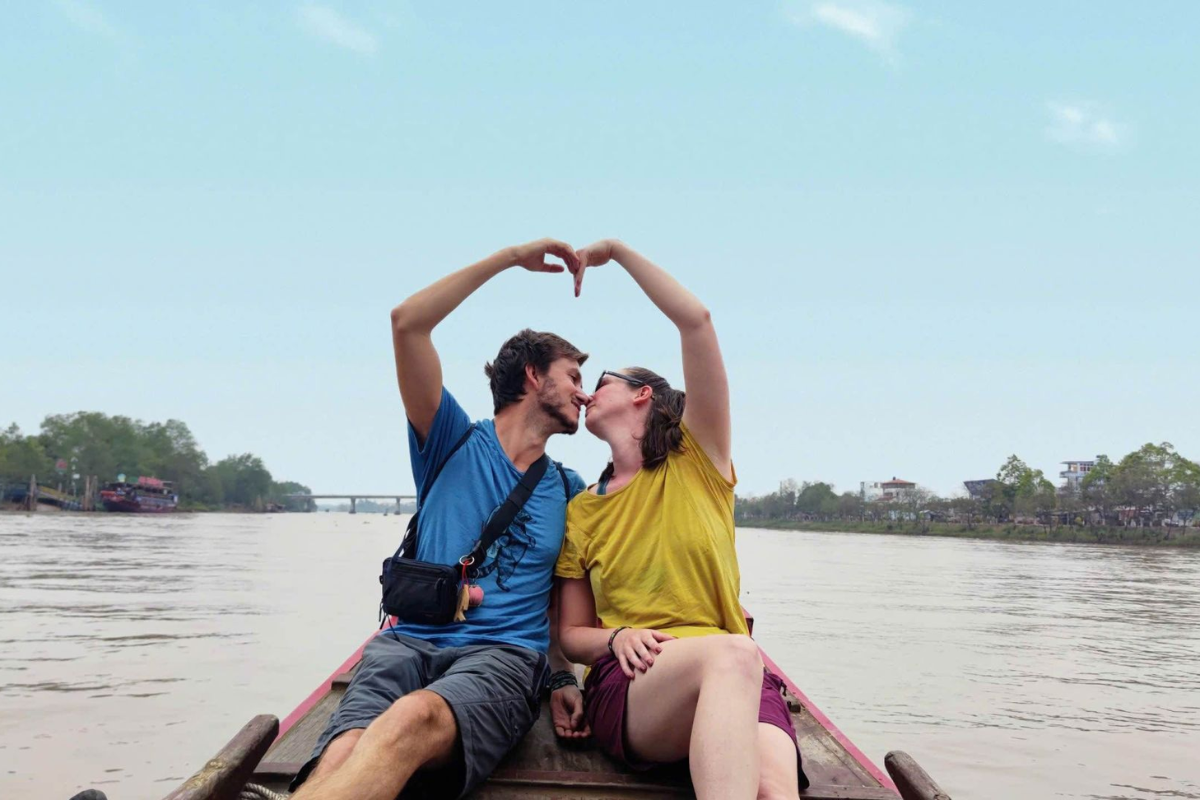 Couple cruising in wooden boat through Mekong Delta canals