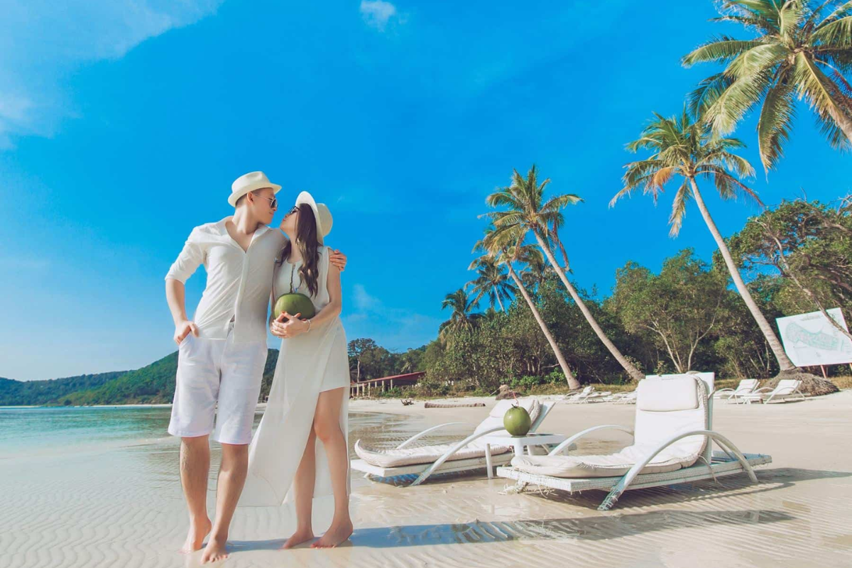 Couple walking on secluded Phu Quoc beach at sunset