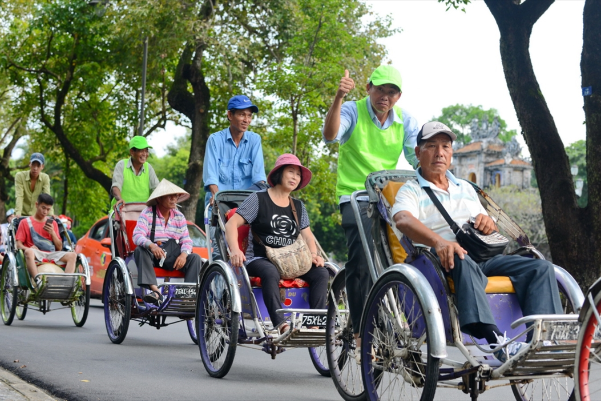 Tourist enjoying a cyclo ride through Hue's streets in January