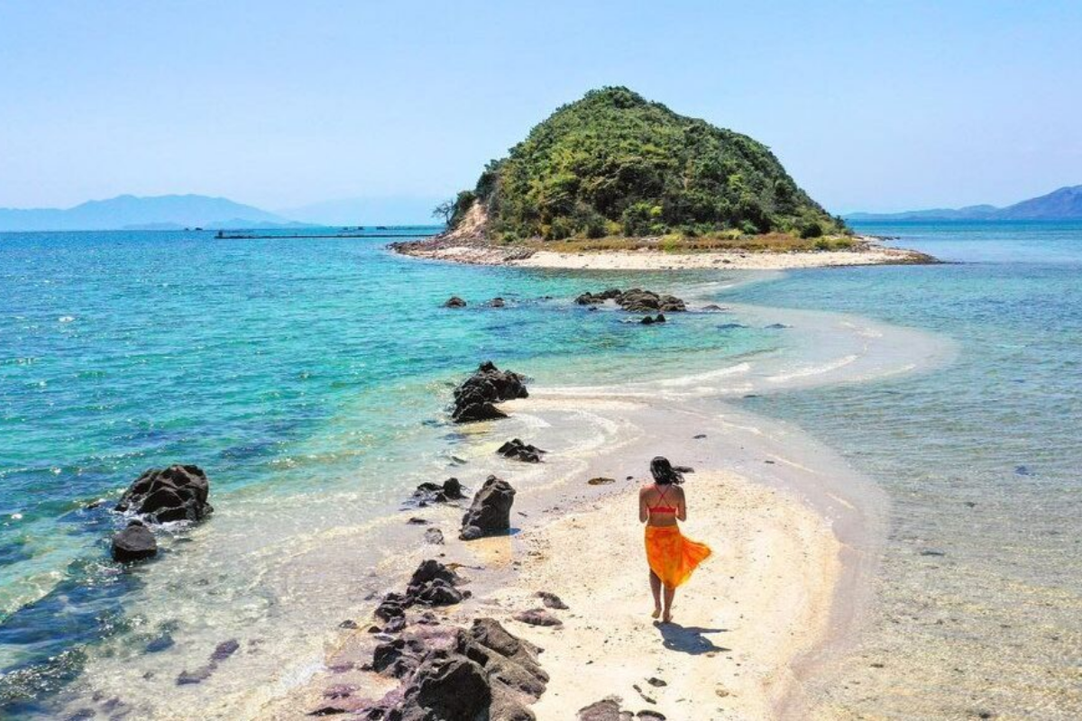 Tourists walking on the narrow sand trail linking the islets of Diep Son Island