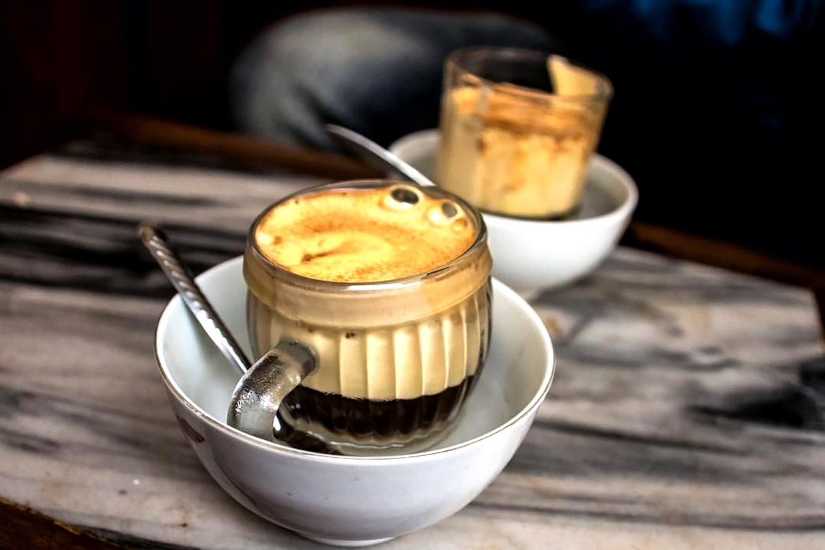 A hot cup of Hanoi egg coffee served in a cozy café