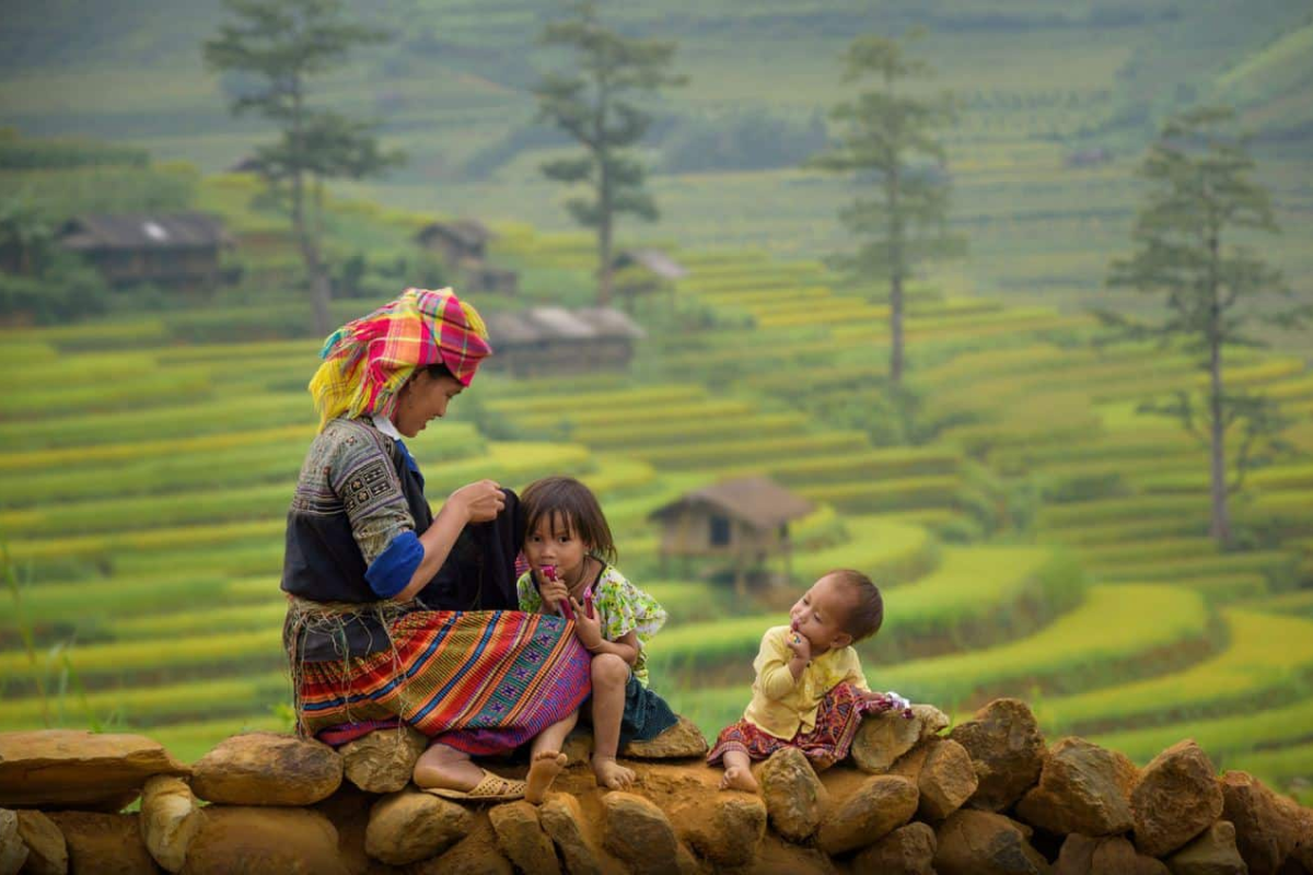 Ethnic minority women in traditional Red Dao and Black Hmong attire in Sapa