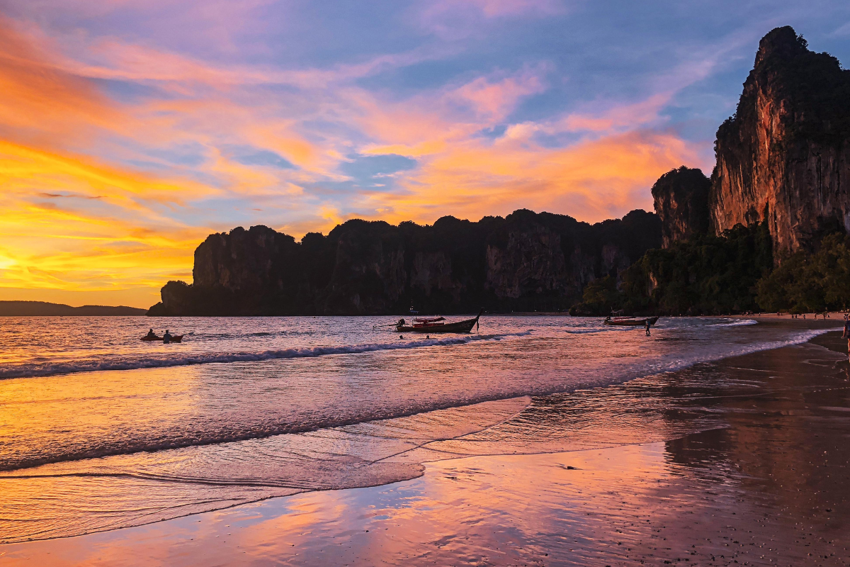 Golden sunset over Thai beach in May with cloudy skies and calm waves