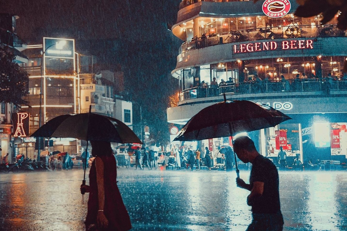 Busy street in Hanoi Old Quarter during a light rain in August