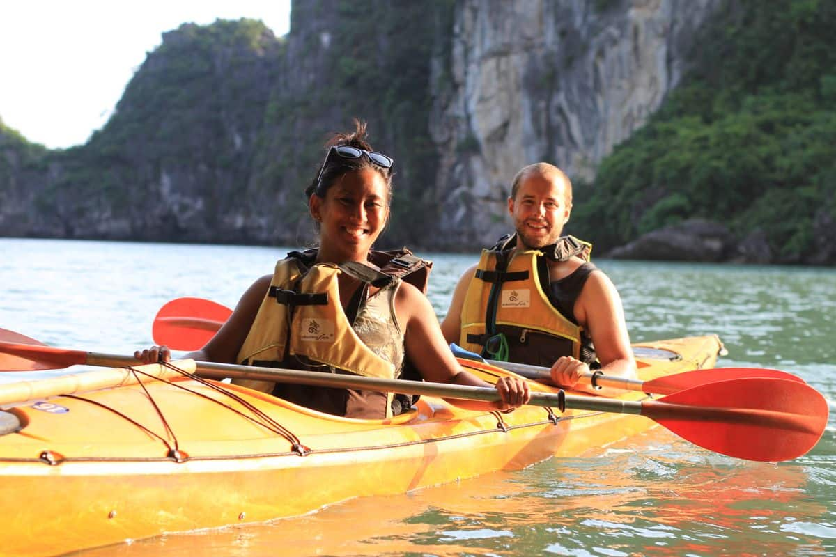 Sea kayaker gliding past limestone karsts in Halong Bay