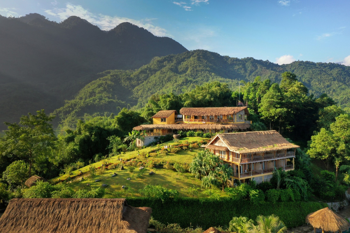 Traditional stilt houses in Lac village surrounded by rice fields
