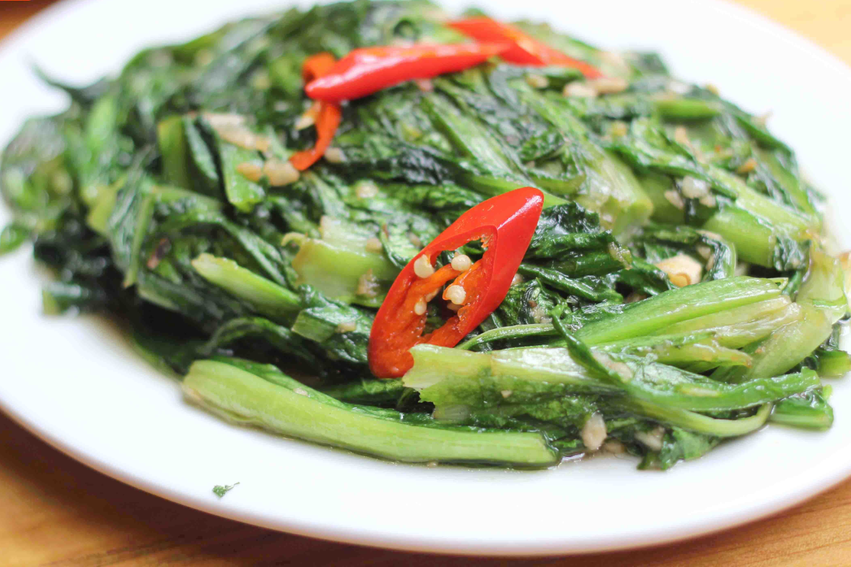 Stir-fried Meo broccoli with garlic served on a traditional Vietnamese dish