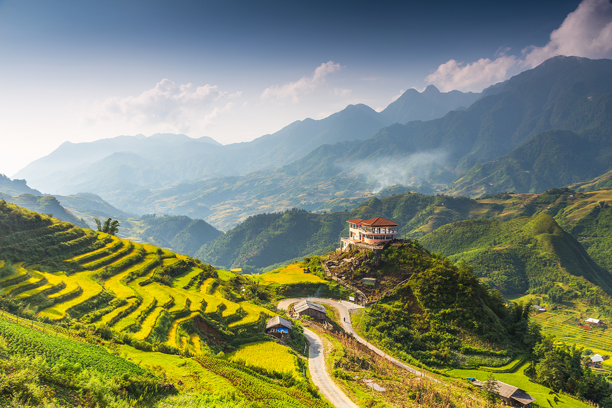 Panoramic view of Muong Hoa Valley with cascading rice terraces and mountains under clear blue sky in Sapa, Vietnam