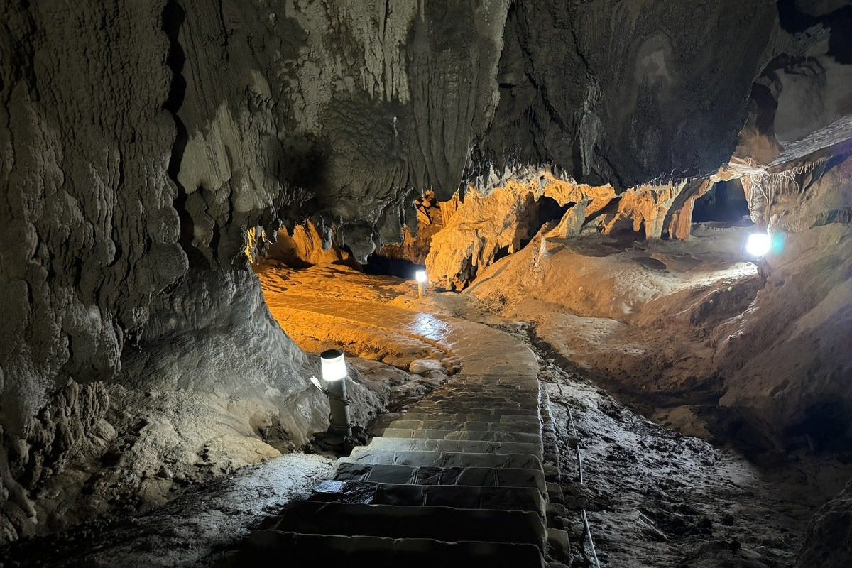 Interior view of Nguom Ngao Cave showing illuminated stalactites and stone formations