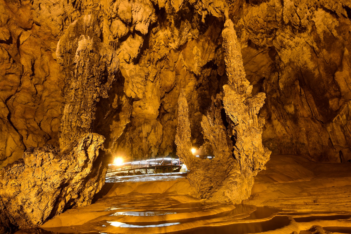 Interior view of Nguom Ngao Cave with stalactites and dim lighting