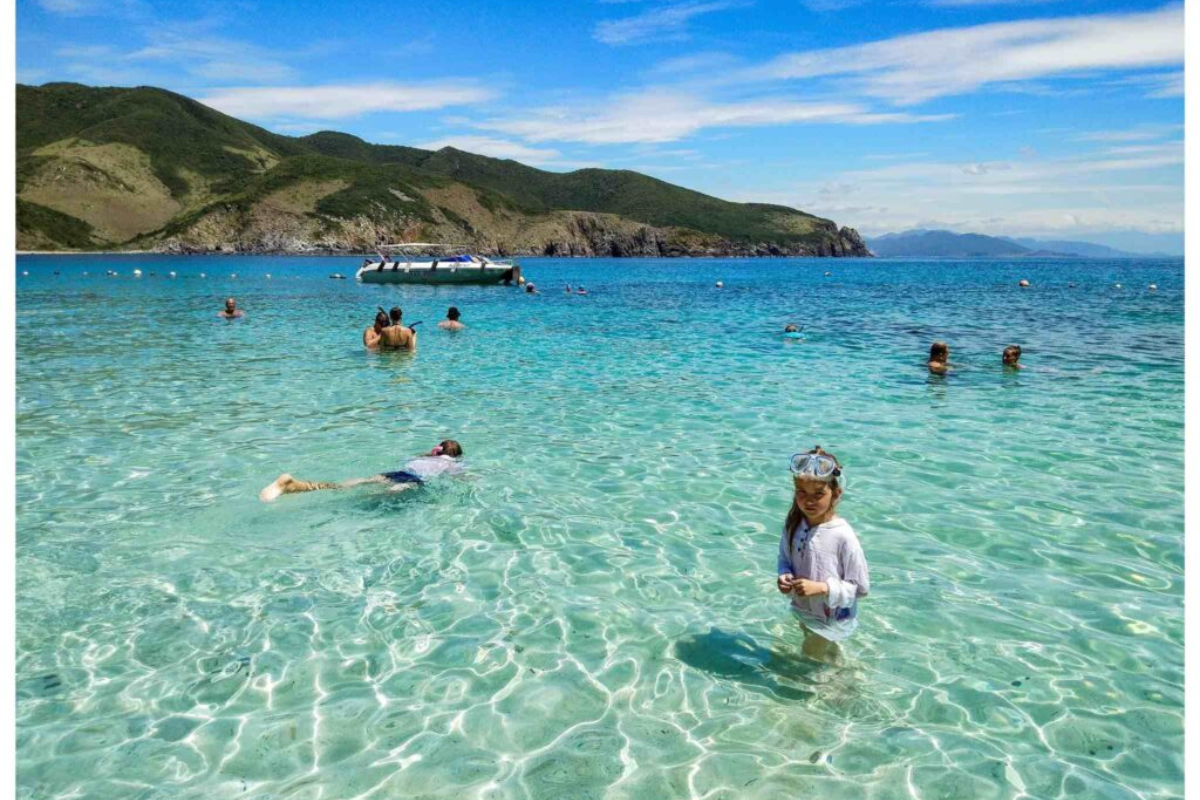 Visitors enjoying the pristine blue waters of Non Nuoc Beach
