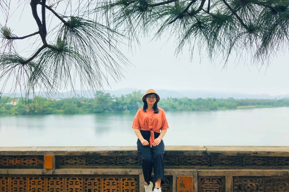 Tourists walking along the peaceful banks of the Huong River in April.