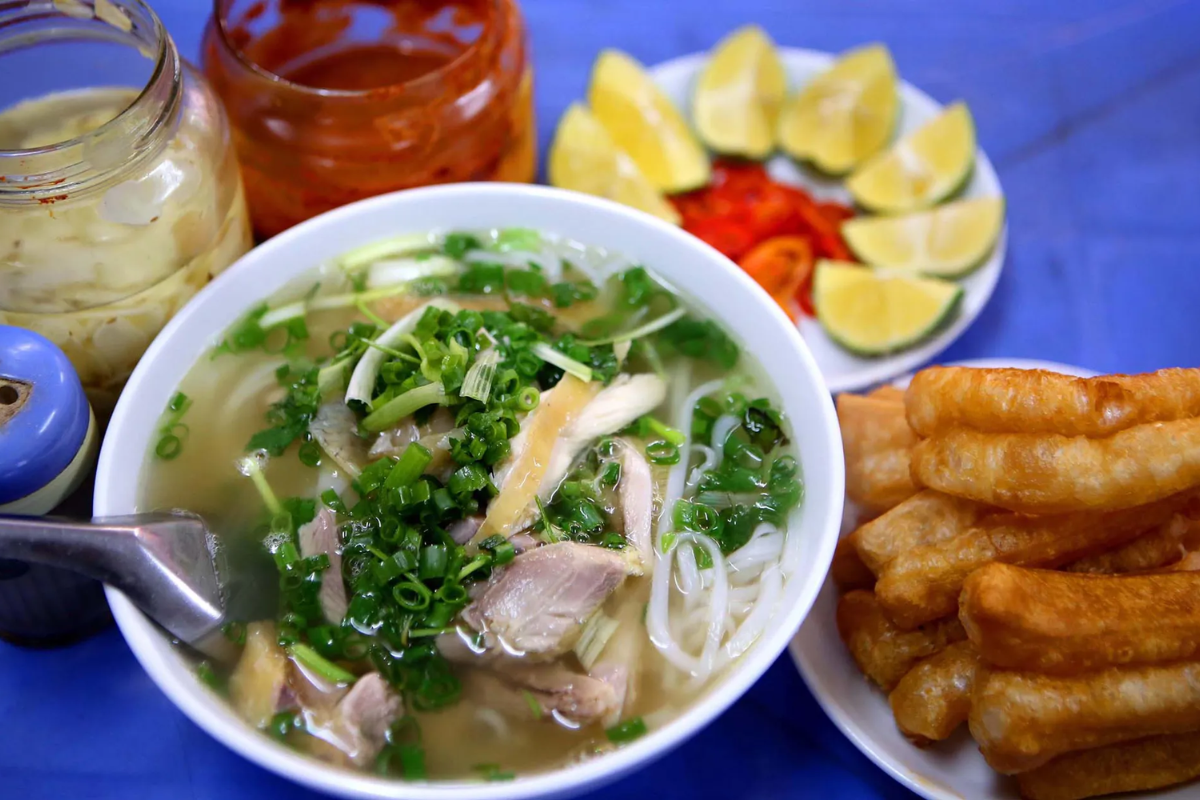 Street vendor preparing a bowl of pho in Hanoi during summer