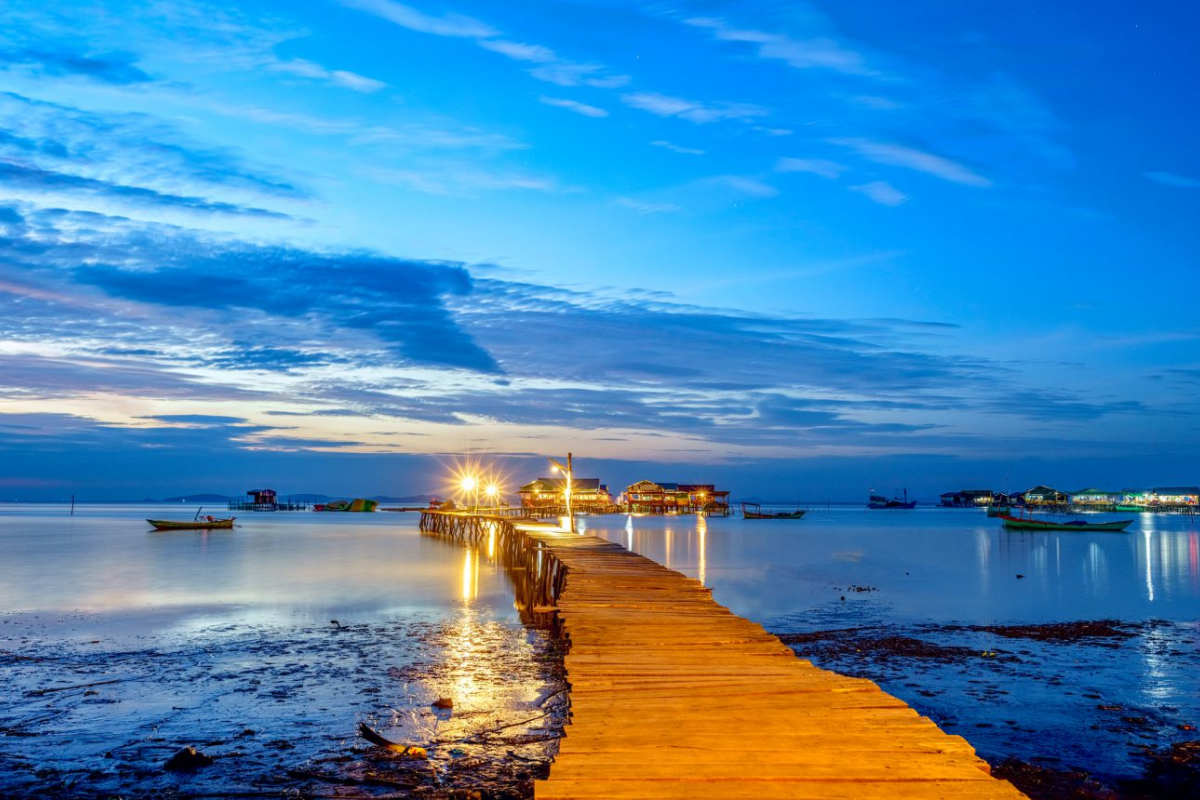 Wooden bridge at Rach Vem Fishing Village over clear shallow waters