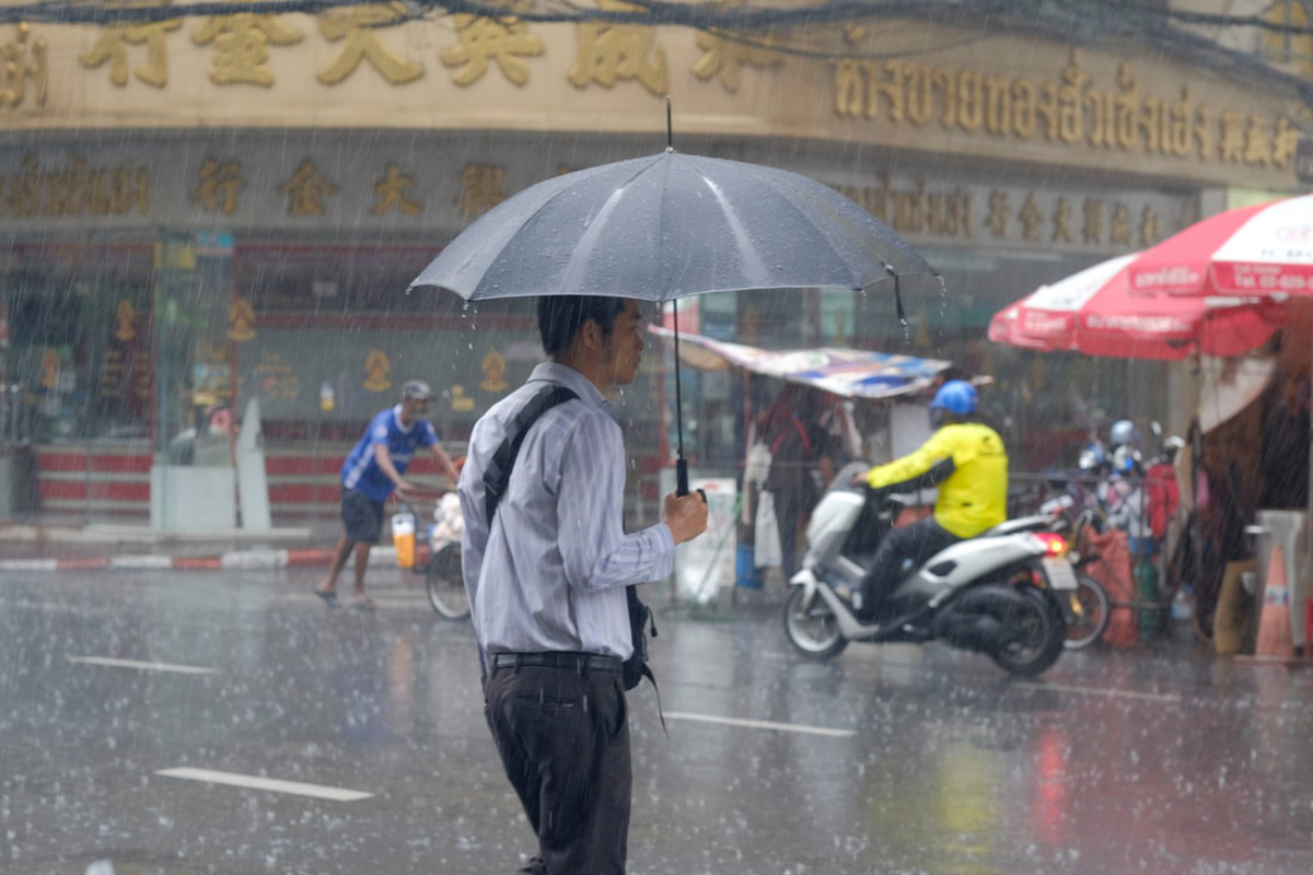Tourists walking under umbrellas during a light rain in Thailand in April