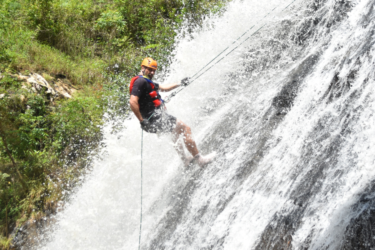 Traveler rappelling beside a waterfall in Dalat