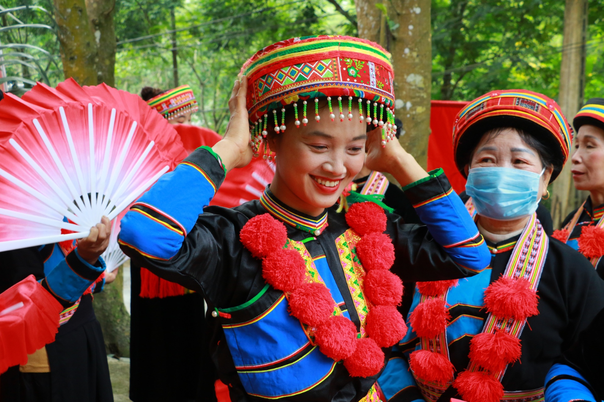 Red Dao women wearing traditional red headscarves and embroidered costumes in Ta Phin village