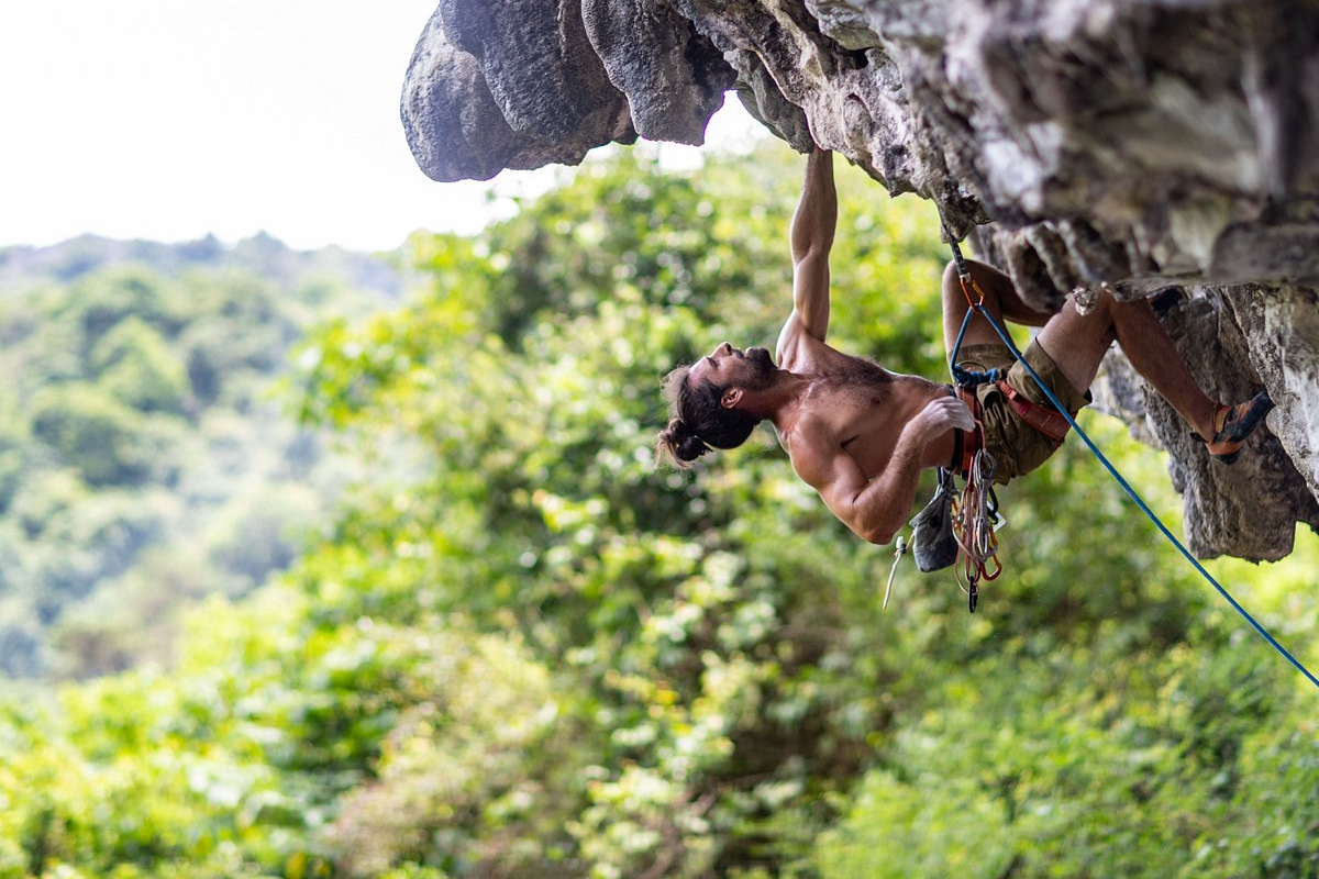 Rock climber scaling a cliff on Cat Ba Island