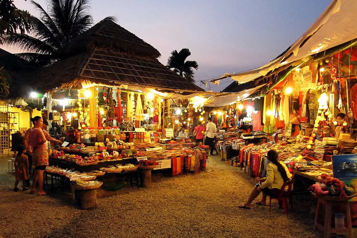 Night market in Ho Chi Minh City with locals eating street food under lights