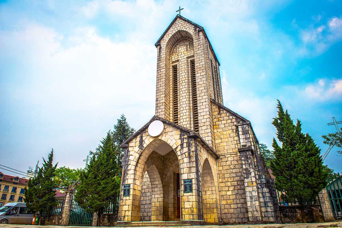 Front view of Sapa Stone Church with mountains in the background