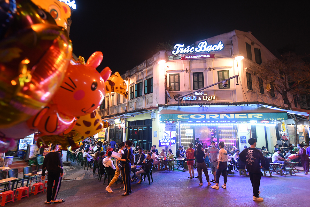 Crowded Ta Hien Street with tourists enjoying food and drinks at night