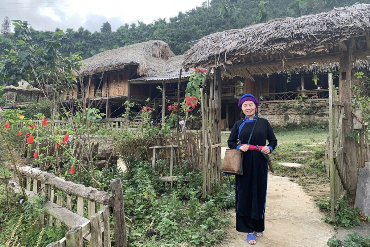 Tay women in Ban Lien wearing traditional indigo tunics with colorful sashes