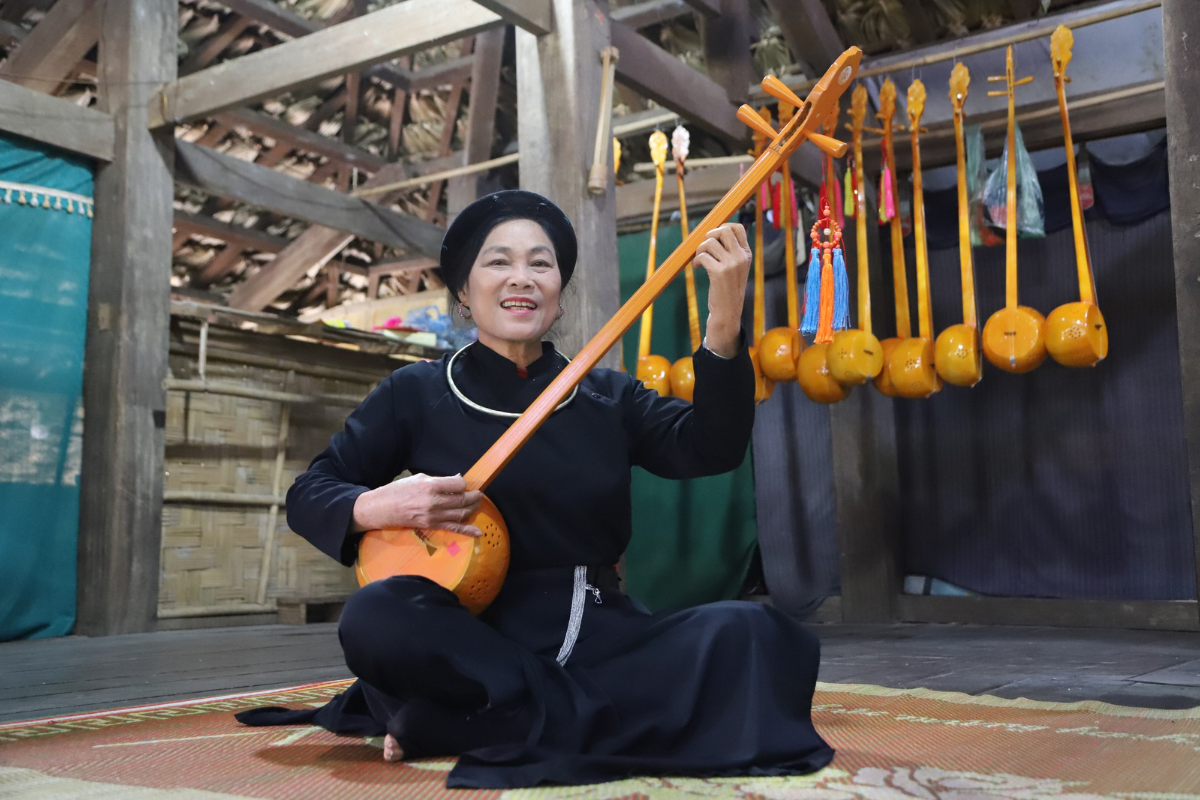 Tay elder playing Tinh instrument in a village ceremony