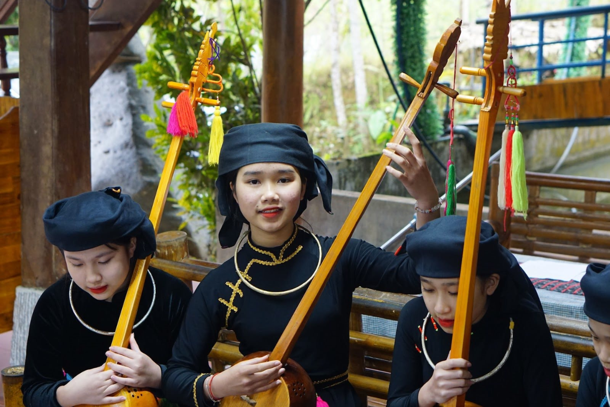 Tày woman performing Then singing with Tinh lute in traditional dress