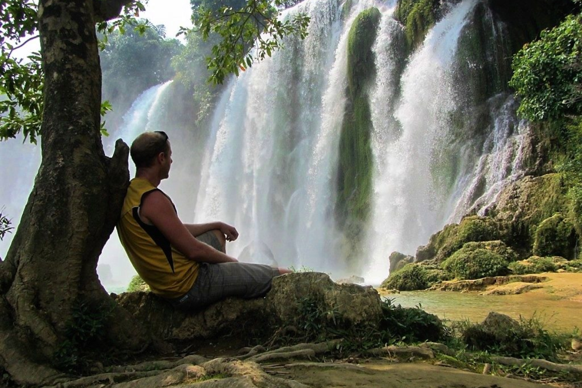 A tourist sits near Ban Gioc Waterfall in January